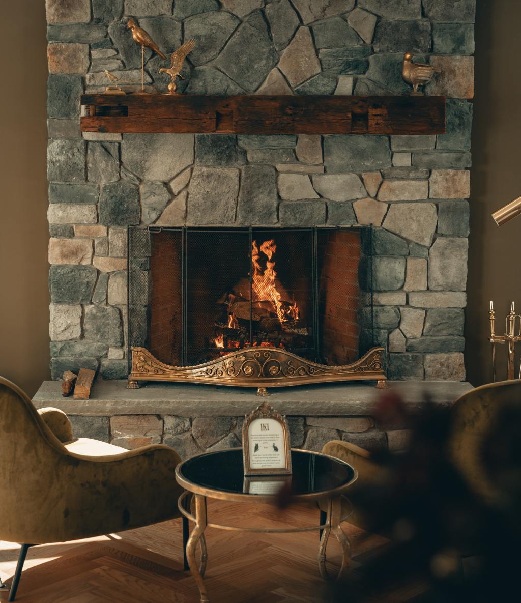 A fire burning in a stone fireplace in a cozy sitting room
