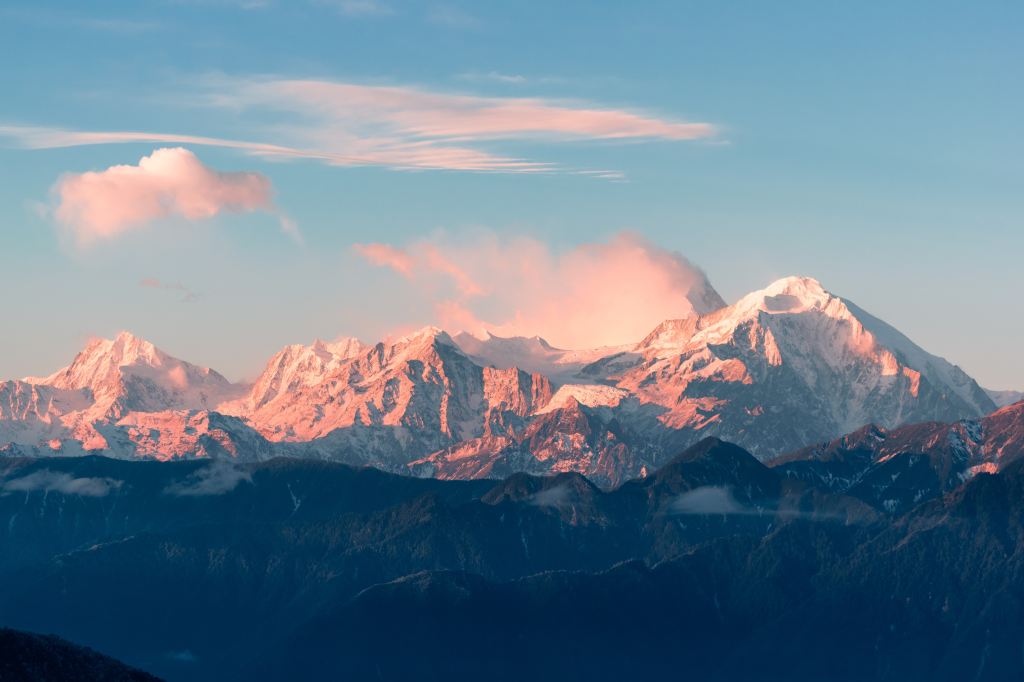 Snow-capped mountain peaks lit pink by the sun